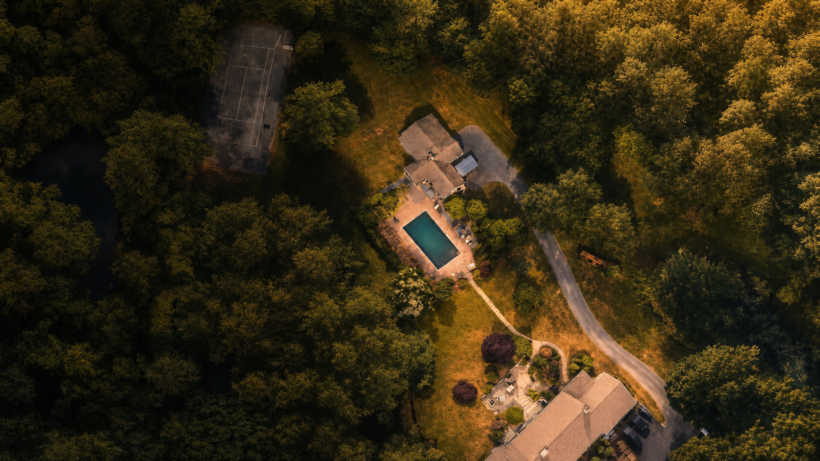 Golden-hour aerial view of The Compound's wooded property