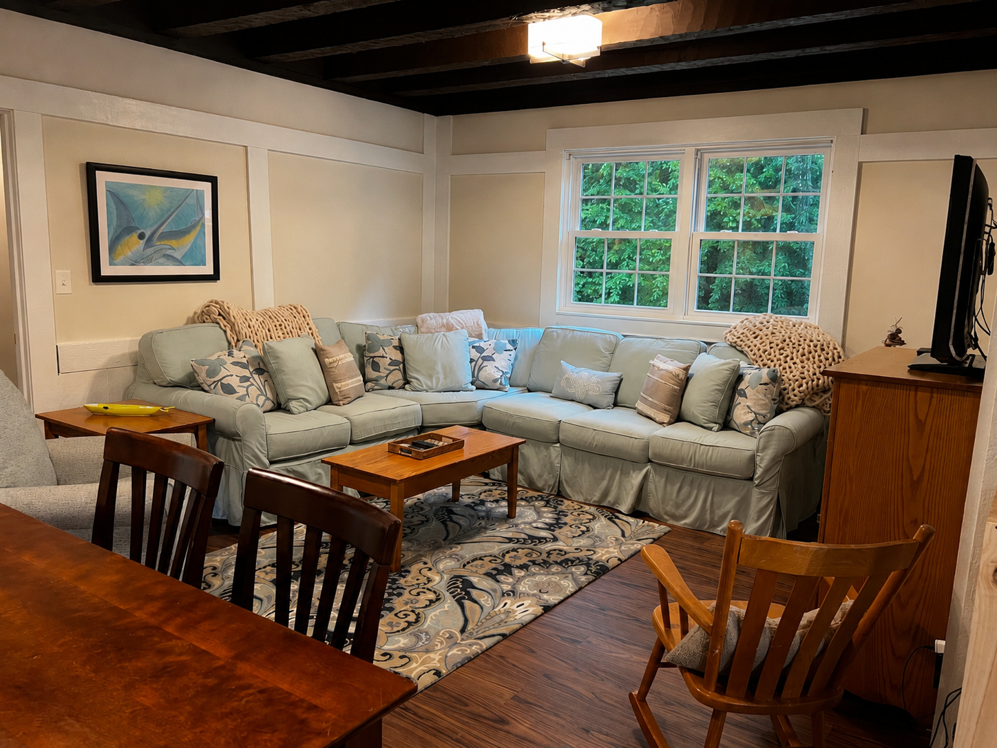 Guesthouse living room with exposed beams and sectional seating